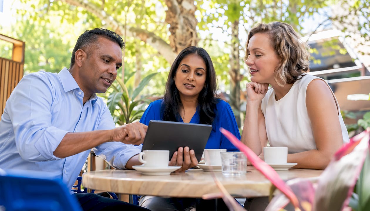 Team discussing chatbot integration with tablet in meeting room