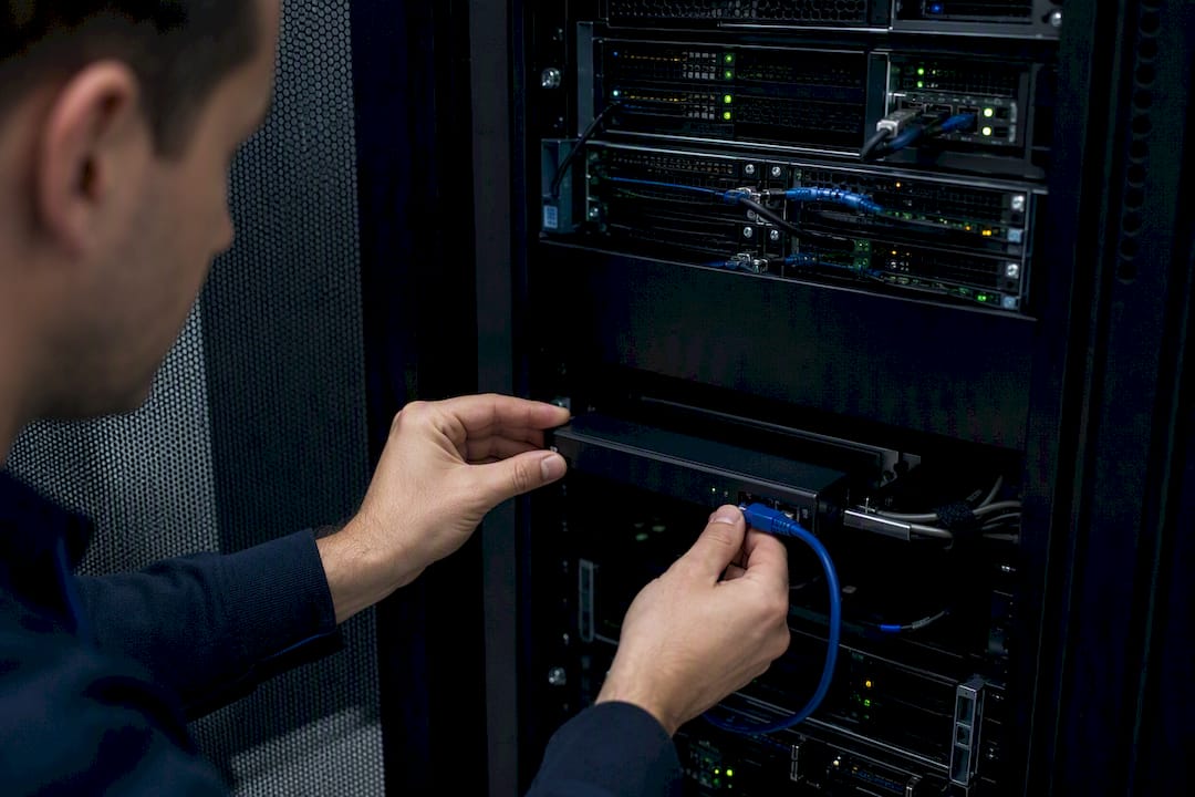 Hands installing security device in server rack