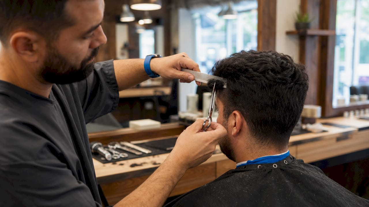 Barber performing scissor-over-comb haircut close-up
