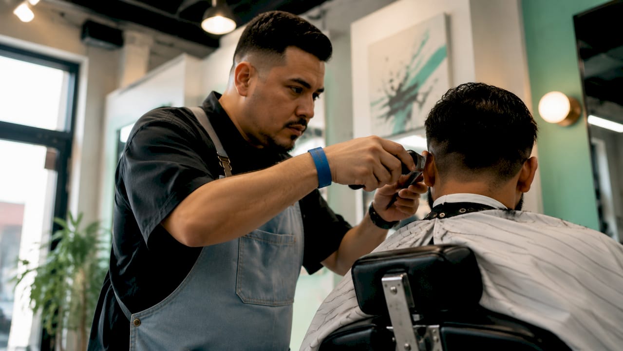 Barber trimming client’s natural hair