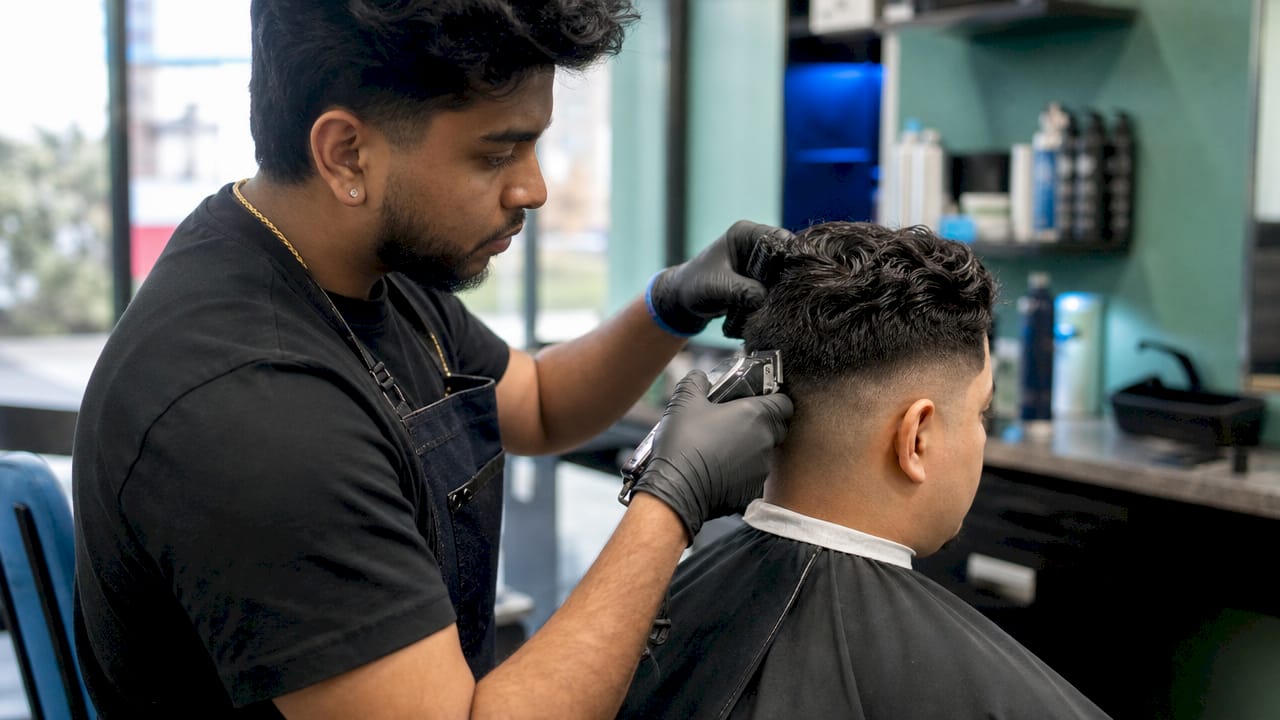 Barber performing taper fade haircut