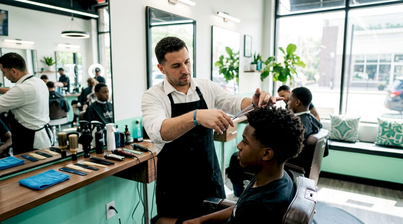 Barber cutting curly textured hair with shears