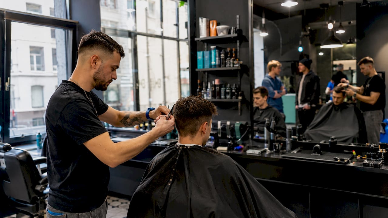 Stylist cutting hair in chain salon
