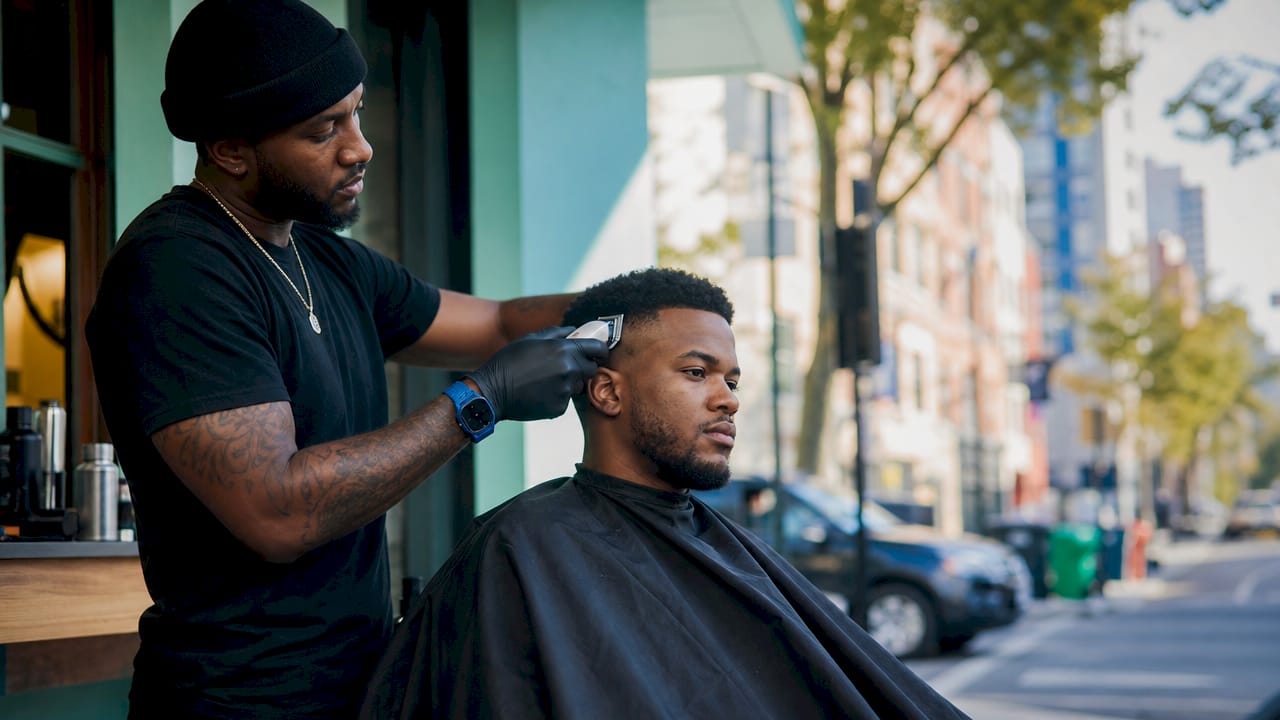 Barber blending fade on male client close-up
