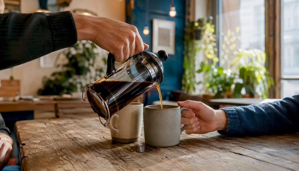 Pouring coffee into cups during informal meeting