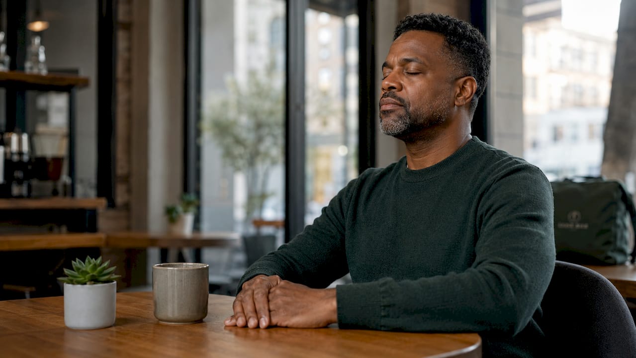 Man practicing breathing exercise at desk