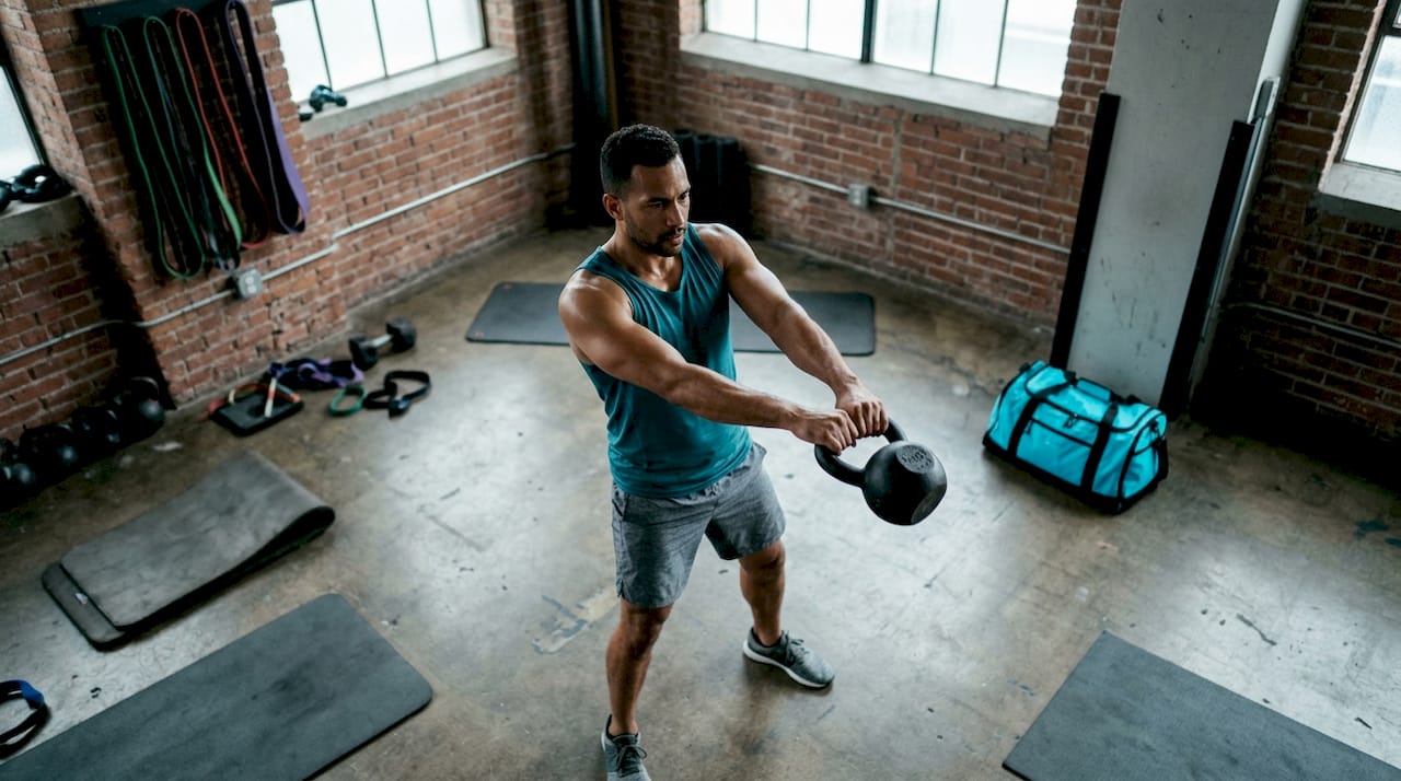 Athlete performing kettlebell swing in gym