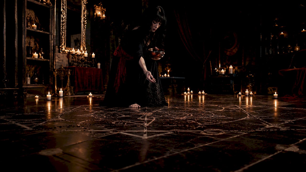 Hands sprinkling black salt at doorway threshold