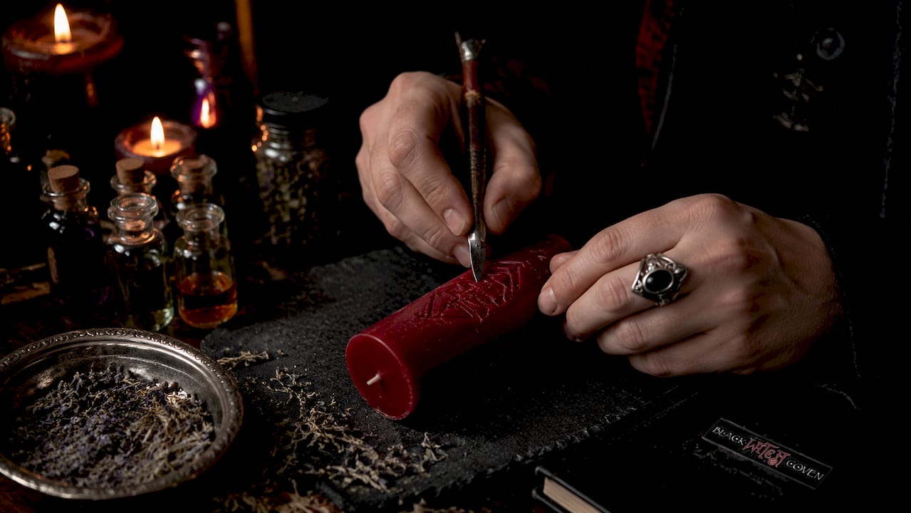 Hands carving and preparing ritual candle