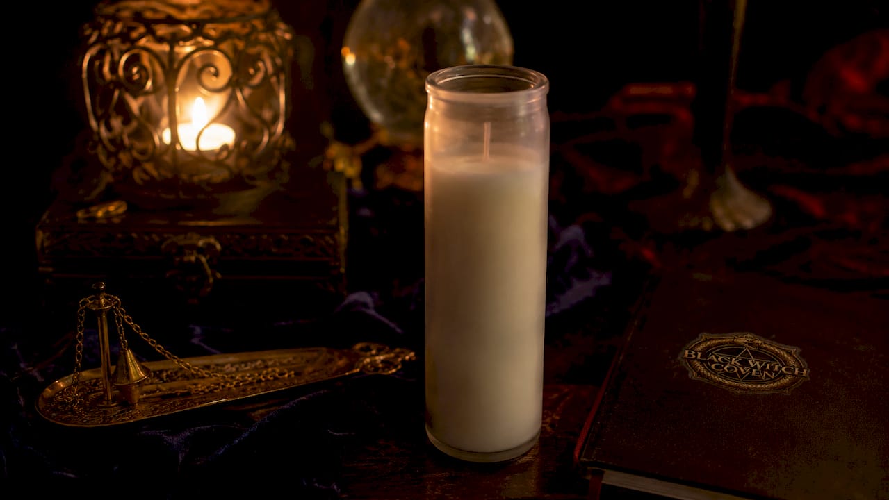 Close-up of unlit seven day candle with ritual tools