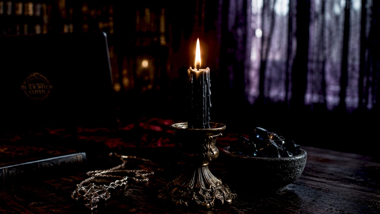 Close-up of burning black candle absorbing energy