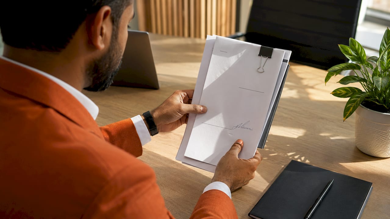 Hands holding certified translation certificate and documents
