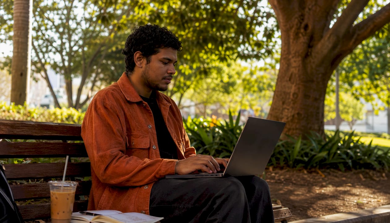 Man verifying NAATI credentials at home office desk