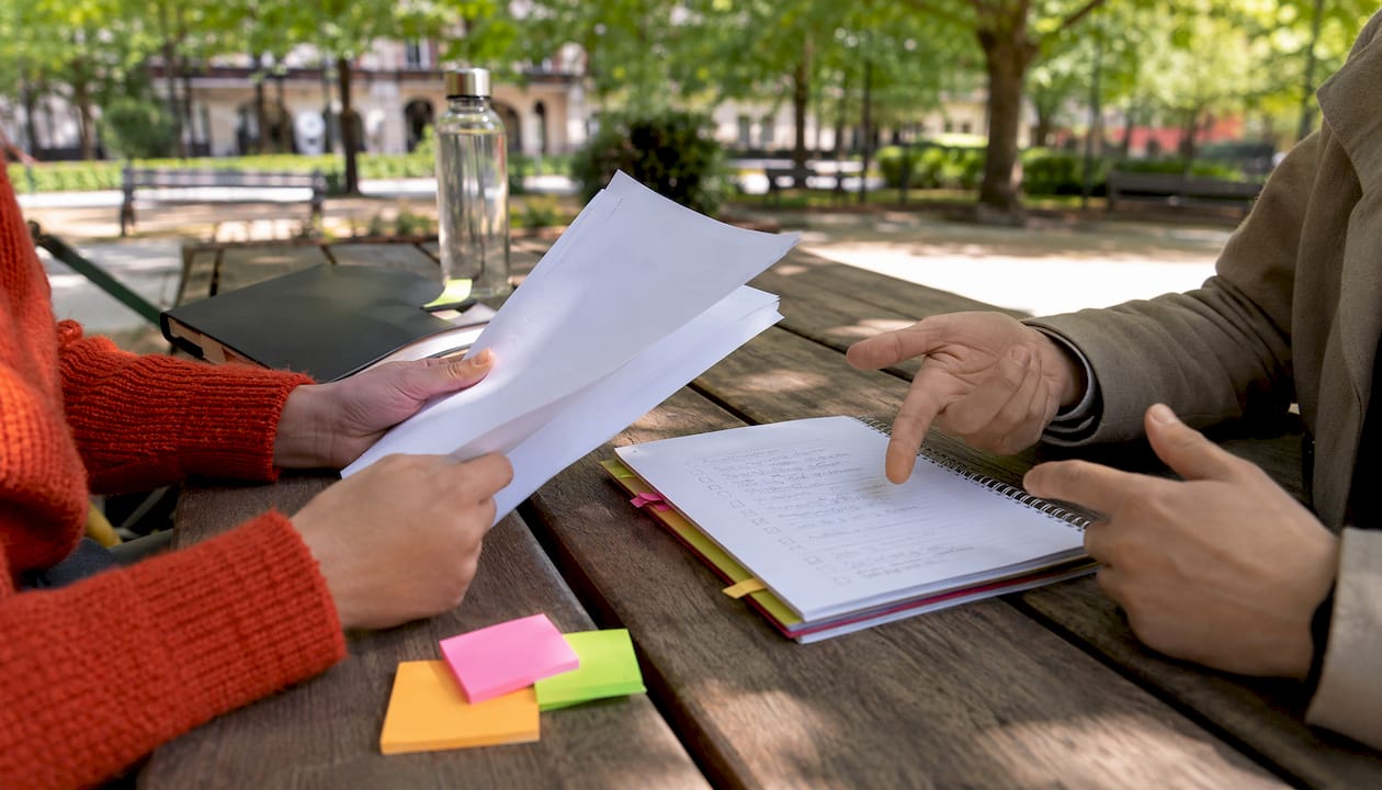 Hands collaborating over translation workflow documents