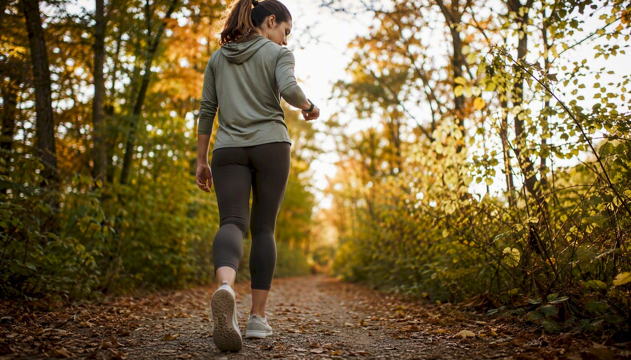 Close-up of woman walking outdoors with fitness tracker