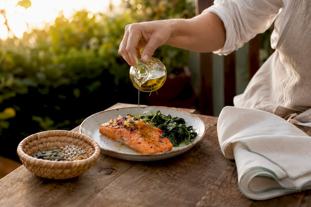 Hands adding seeds to salmon meal