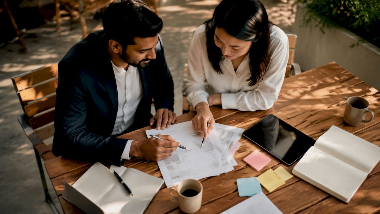 Two entrepreneurs discussing value proposition drafts at coworking space