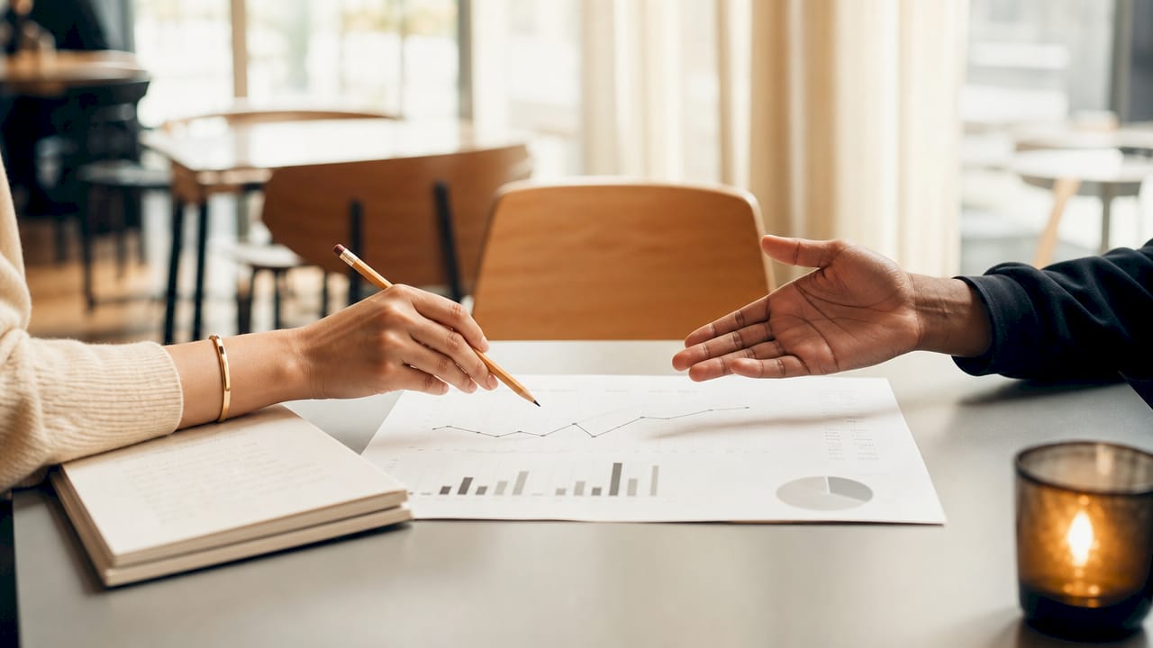 Hands pointing at business growth metrics chart