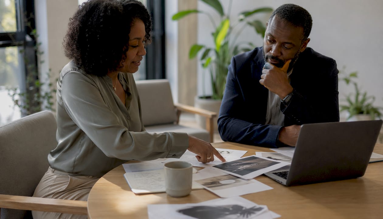 Two professionals discussing AI presentation decisions at table