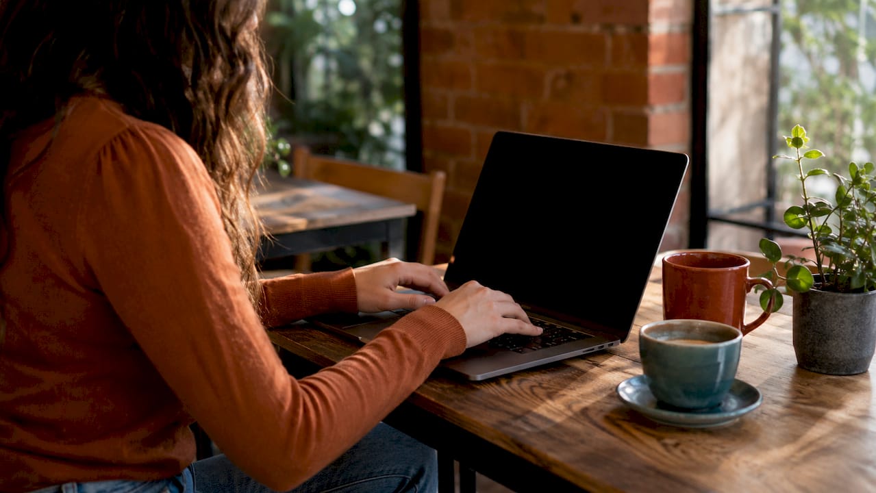Hands typing laptop in office CI/CD pipeline