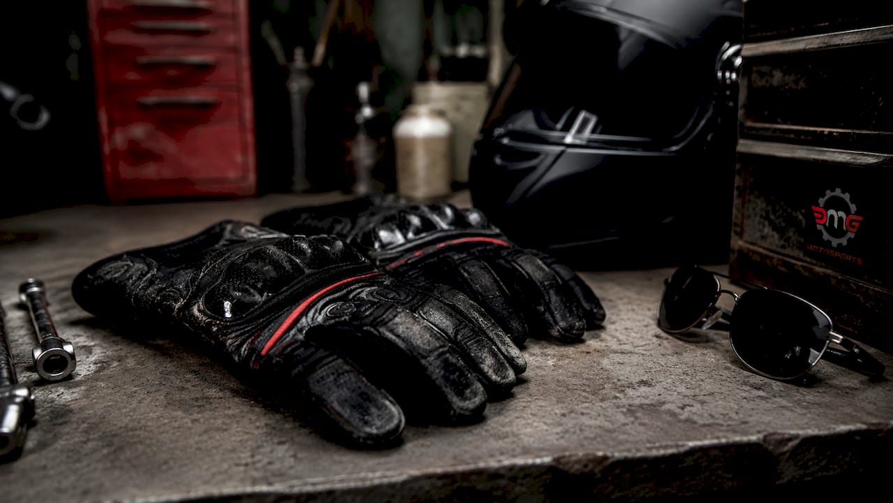 Overhead view of motorcycle gloves on workshop bench