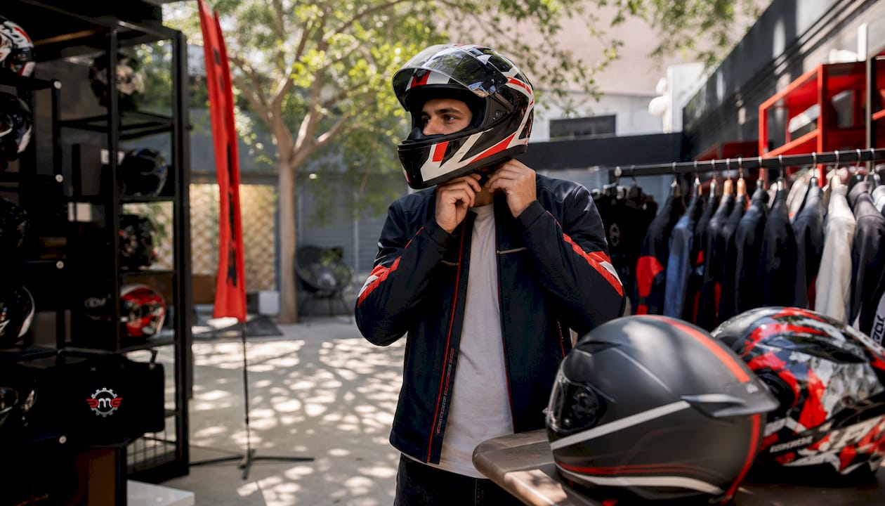 Man fitting motorcycle helmet outdoors