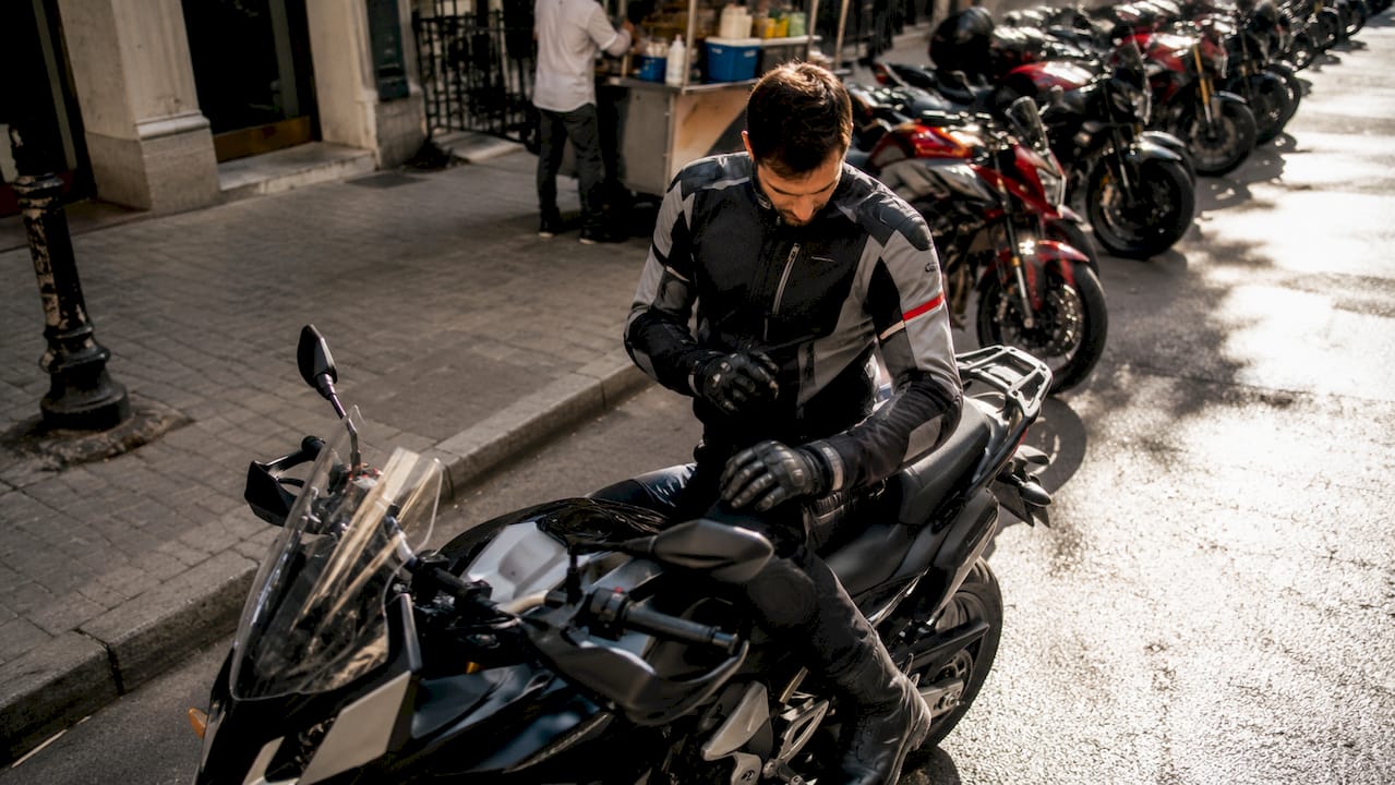 Motorcycle rider adjusting posture on bike outdoors