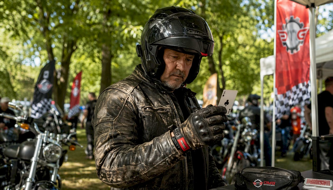 Motorcyclist checking playing card at checkpoint