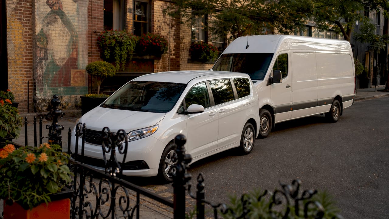 Various corporate van types parked urban street
