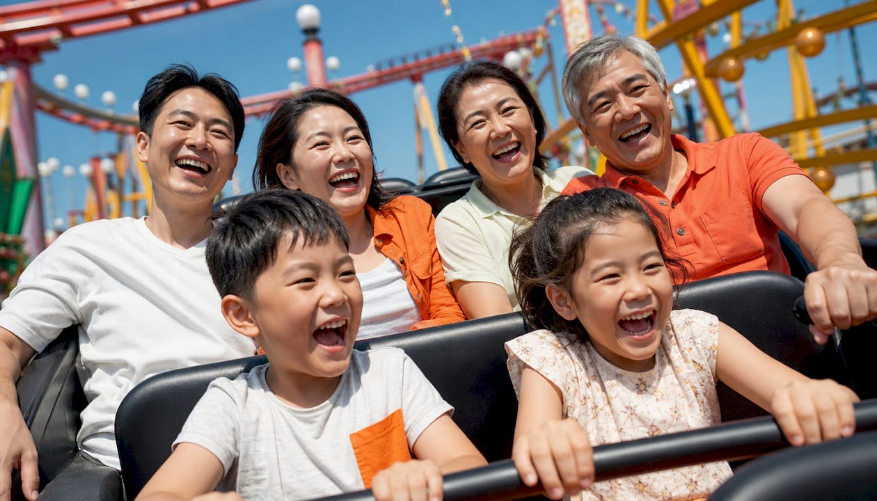 Multi-generation family enjoying theme park ride