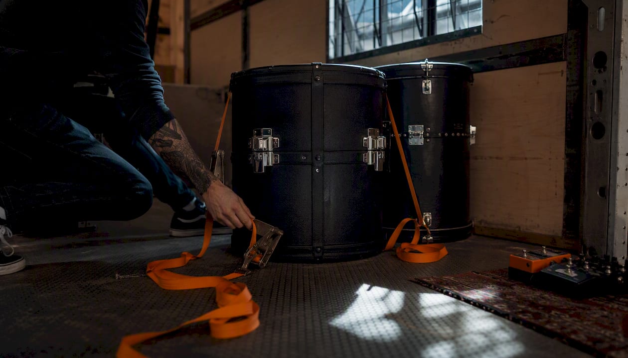 Hand placing drum cases over rear axle