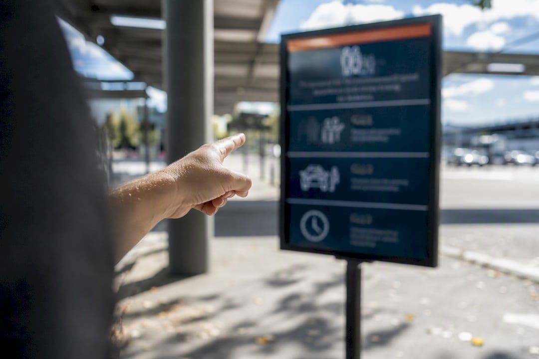 Hand pointing at airport pickup wait policy sign