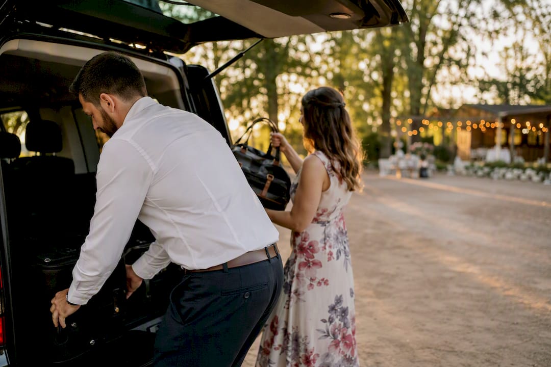 Guests loading luggage into van at wedding