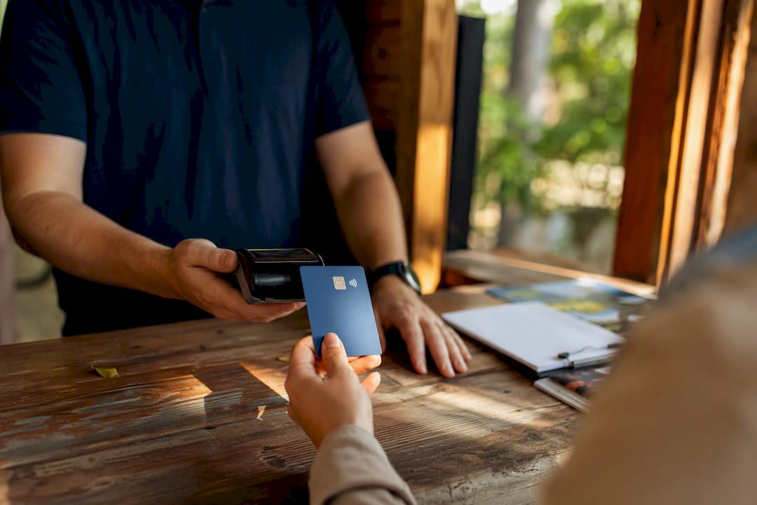 Hands holding debit card over rental desk
