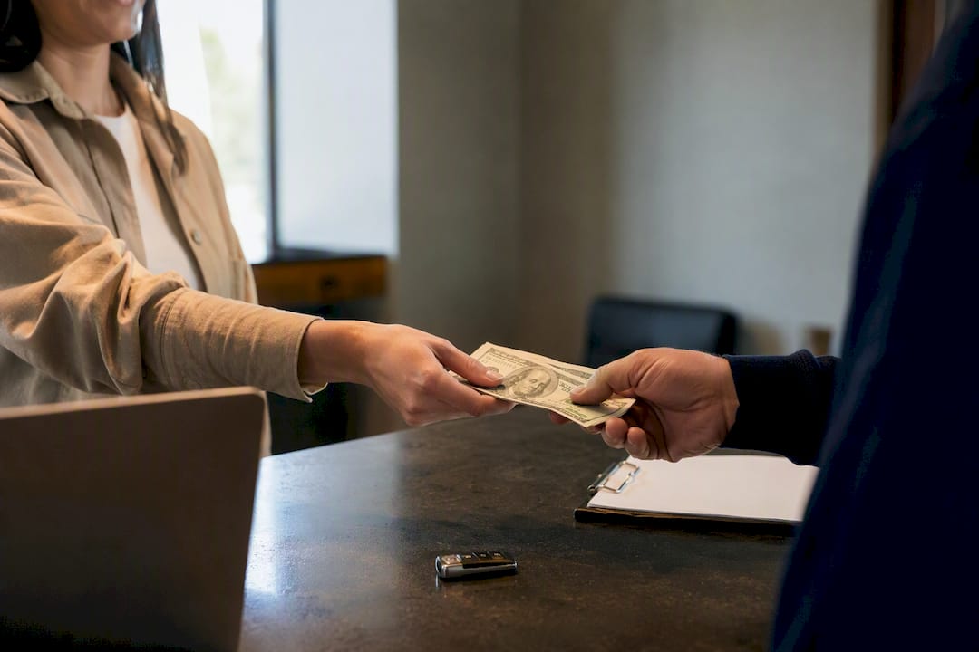 Hand paying cash at rental counter