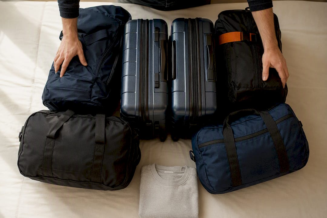 Duffel bags packed around hard suitcases