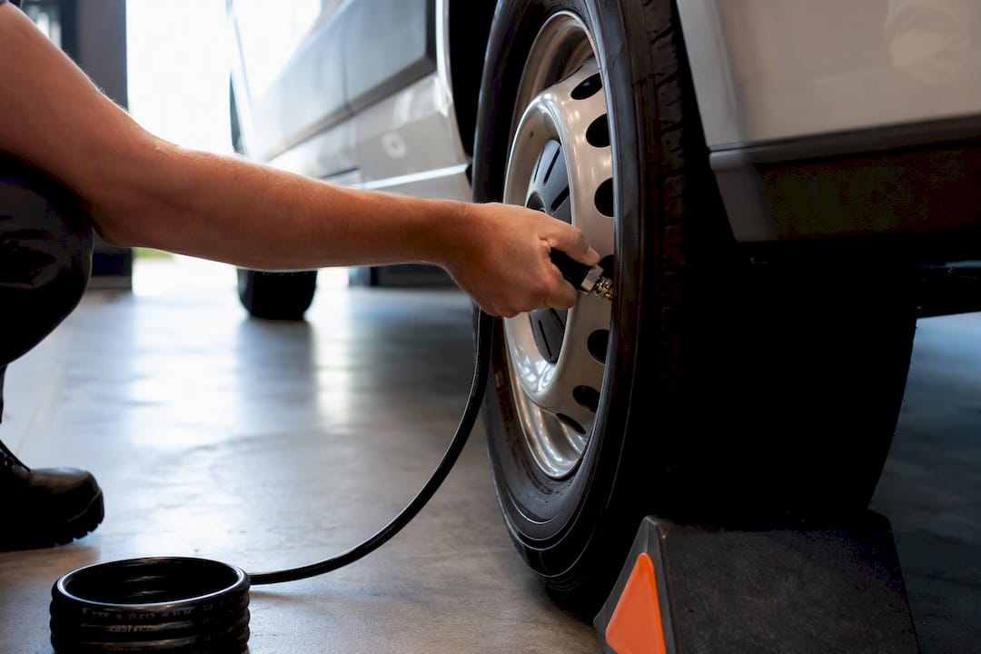 Hand checking passenger van tire pressure