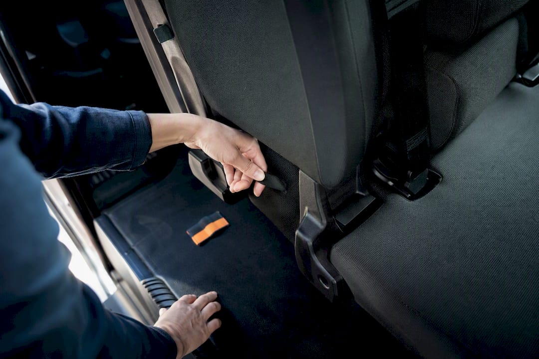 Hands checking second-row car seat anchors
