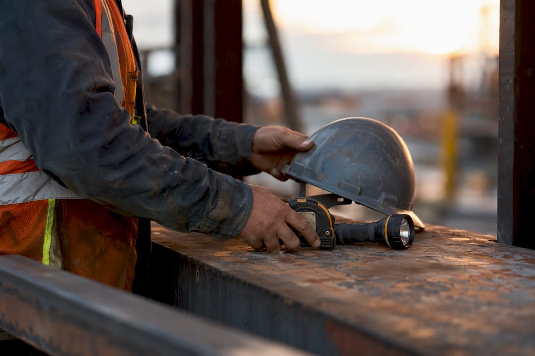 Foreman's hands with construction tools on workbench