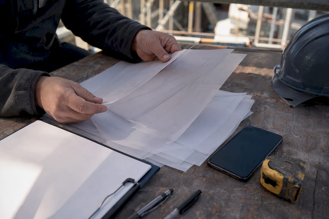 Hands managing subcontractor schedules on bench