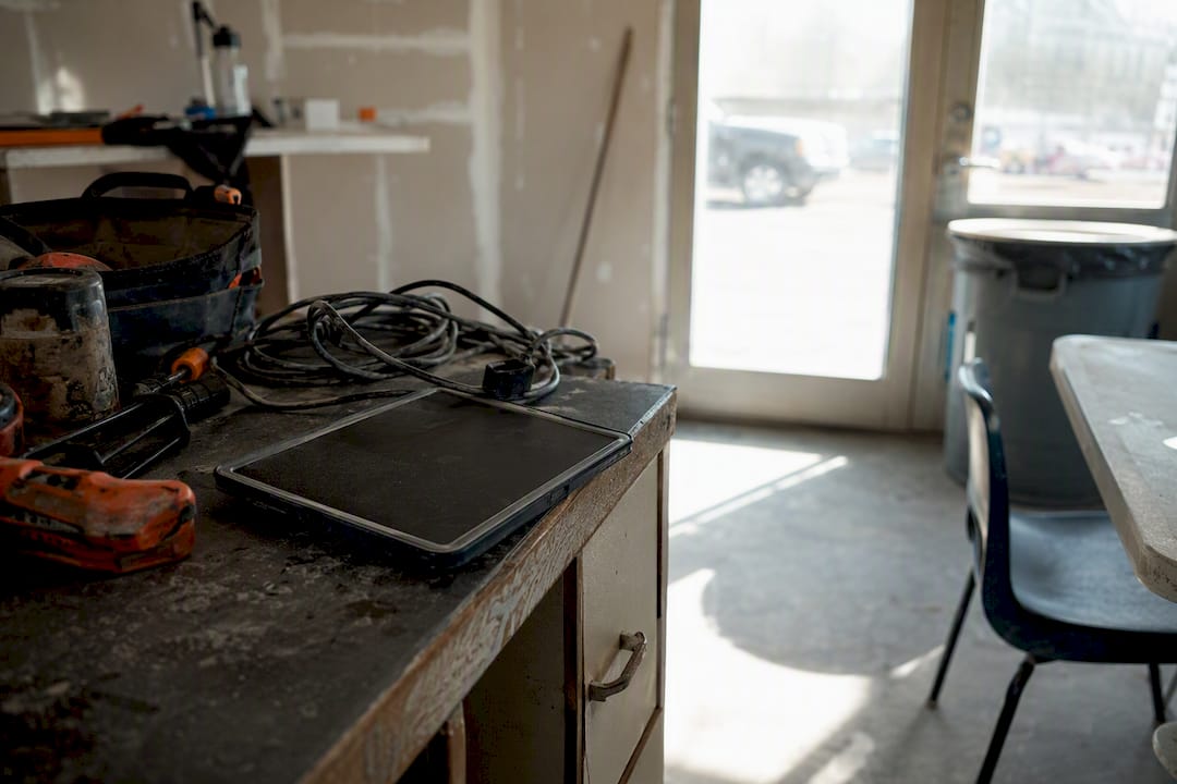 Unused digital tablet on dusty construction trailer bench