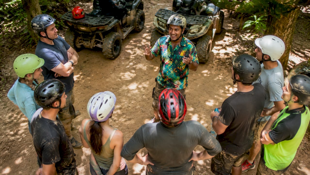ATV guide briefing riders at dirt trail checkpoint