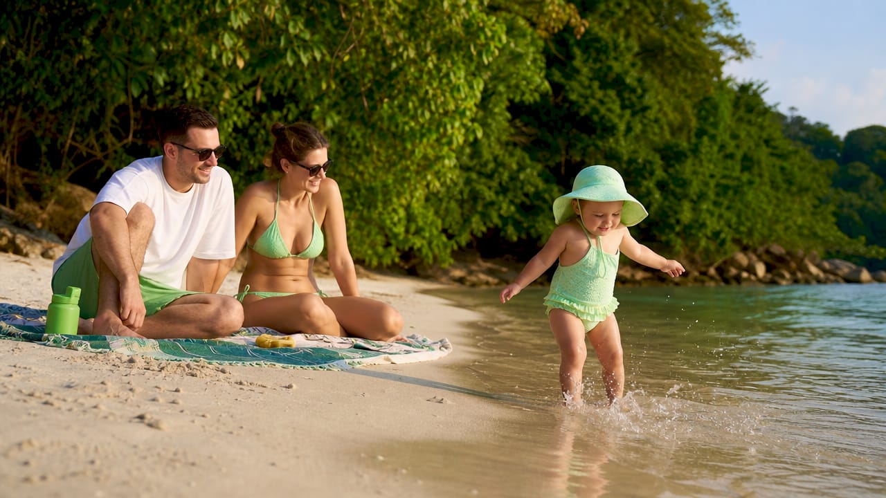 Family with toddler at calm safe Phuket beach