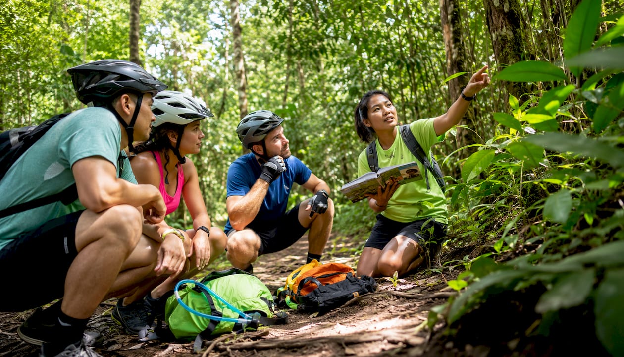 Group listening to guide in jungle clearing