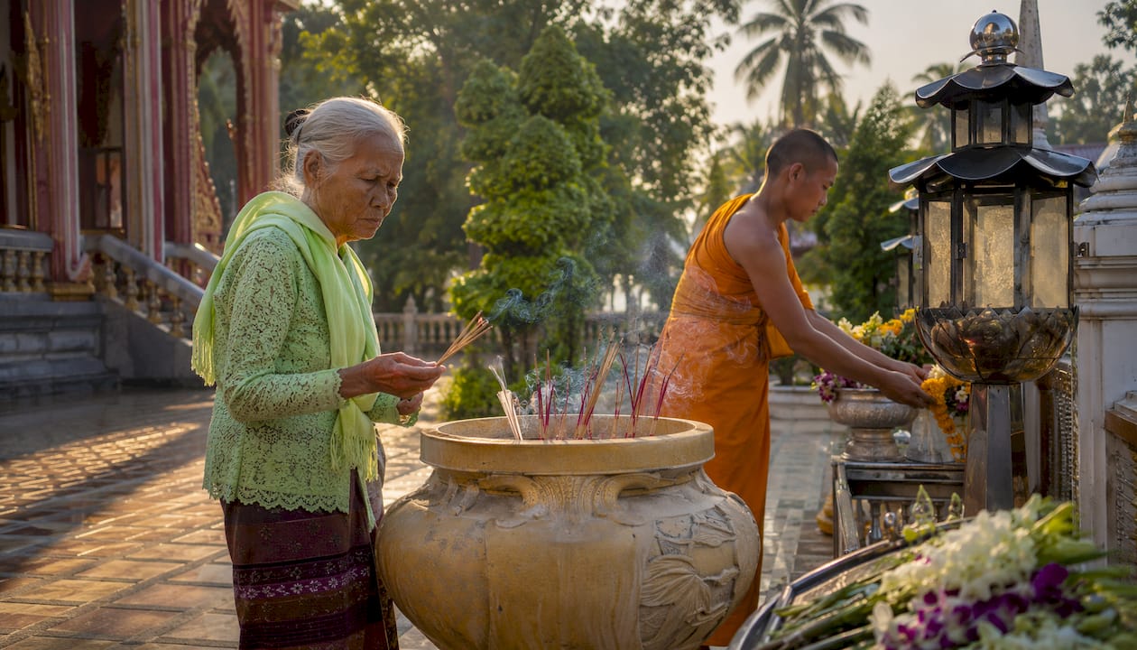 Locals lighting incense inside Wat Chalong temple