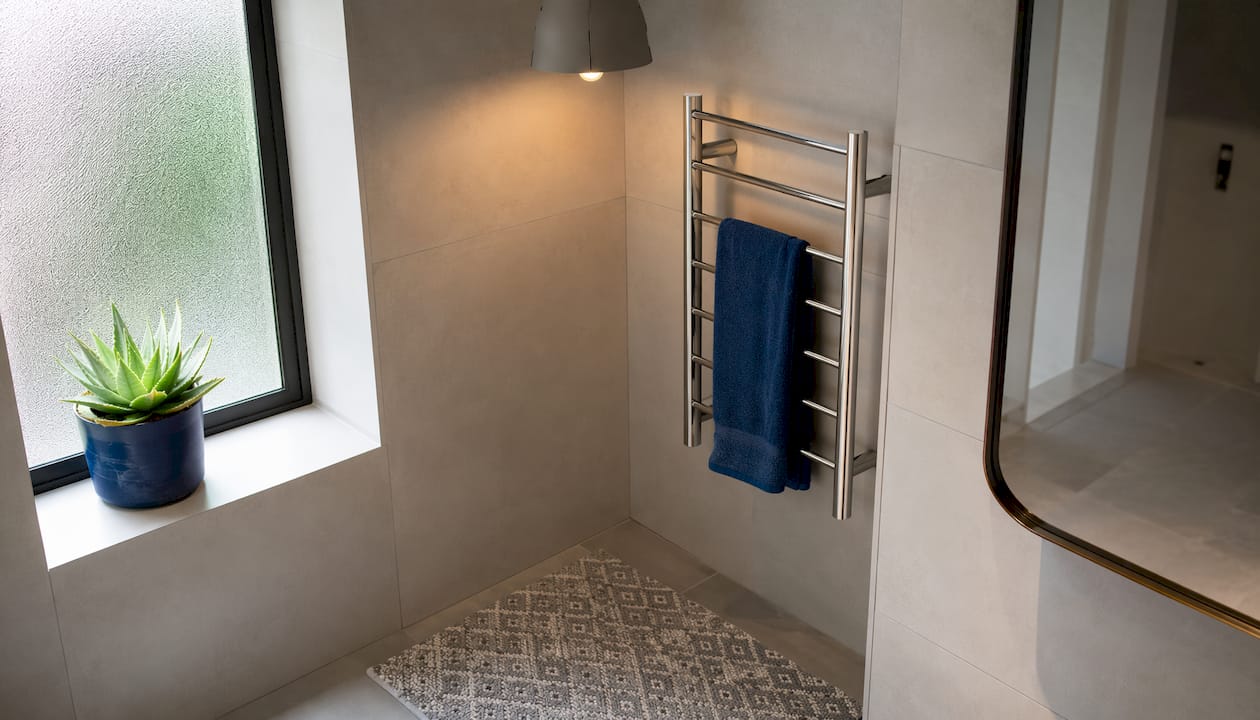 Lighted cream tiled bathroom corner