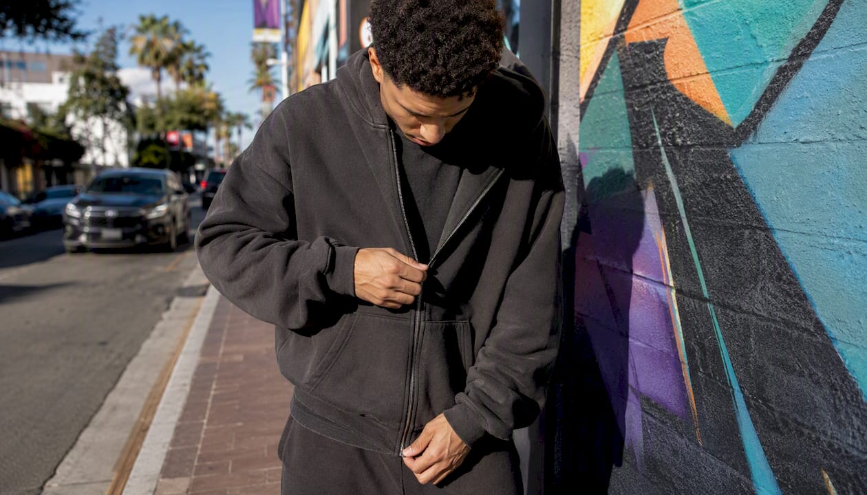 Man layering heavyweight zip hoodie over tee