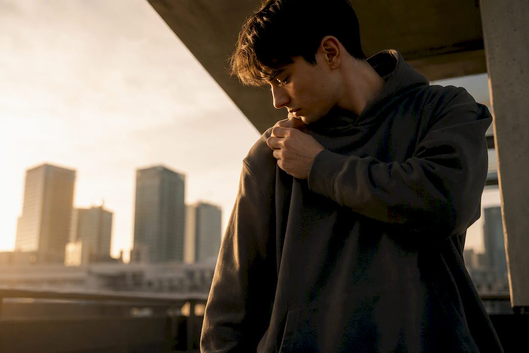 Model adjusting hoodie shoulder for fit