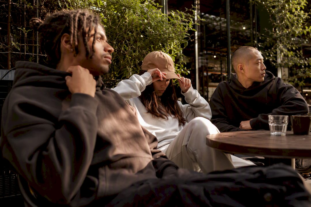 Diverse people adjusting streetwear outfits outside