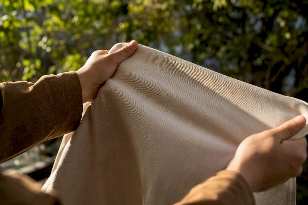 Hands stretching heavyweight cotton fabric
